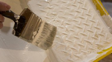 Boya banyosu ve boya fırçası.