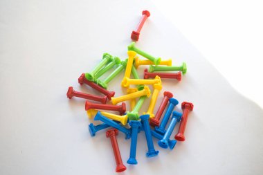 Tasarımcının bir sürü renkli plastik parçasını elinde tutuyor. Gökkuşağı elementleri ellerinde. Bir çocuk için geleceğin mesleğini seçmek. Erken çocuk gelişimi yöntemleri