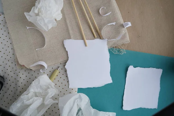 Background with writing paper in zero waste color. Brown and blue colors, white paper, natural fabric and a pen in olive color.