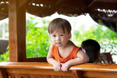 Küçük tatlı Asyalı çocuk gülümsüyor ve kasten bakıyor. Asyalı çocukların sevimli gözleri..