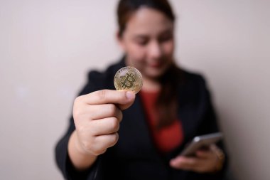 Elinde Bitcoin sikkeleri ve şifreli ticaret çizelgesi olan akıllı telefon olan bir iş kadını. Kripto para değişimi. teknoloji ve yatırım dijital konsepti. Finans, Ticaret, Yatırımcı, Altın Bitcoin Nakit