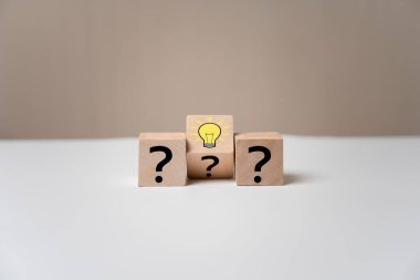 seçilen tahta küp bloğu ampul simgesi ve ikon soru işareti yaratıcı kavramı ile. yeni fikirler