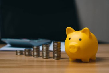 Para ve domuz kumbarası ahşap bir masa üzerinde, para tasarruf ve finansal kavramlar iş finansman yatırım finansal planlama
