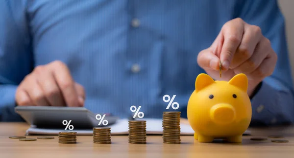 pile of coins and piggy bank, Interest rate and dividend concept Businessman is calculating income and return on investment in percentage. income, return, retirement, compensation fund, investment