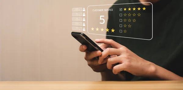 Customer satisfaction concept. Hands of business men using a mobile to comment 5 stars. Satisfaction Rating, good and impressive, after sales service. Excellent business rating, reputation