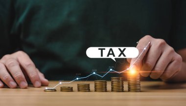 Tax deduction planning concept. Expenses, account, VAT, income tax, and property tax, pay tax. Businessman's hand and pile of coins on the table.