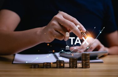 Tax deduction planning concept. Expenses, account, VAT, income tax, and property tax, pay tax. Revenue Department. Individuals calculate annual expenses and taxes. with a pile of coins on the desk