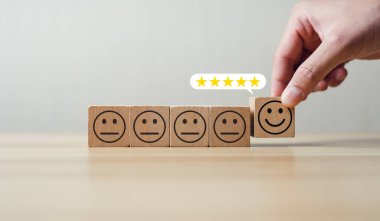 user chooses to rate the service 5 stars smiley face icon on wooden block. Concept after-sales service and comments. satisfaction, good and impressive. Excellent business rating, reputation