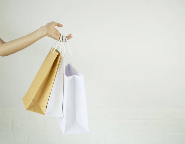 Paper shopping bags, on white background, female hands, holding shopping bags, concept, shopping mall shopping frenzy.