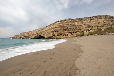 Matala sahilinin panorama 'sı kayalıklarda Roma mezarlığı olarak kullanılan mağaralar ve 70' li yıllarda Girit, Yunanistan 'ın dört bir yanından hippiler yaşıyordu.
