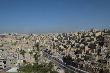 Amman Skyline modern binalar ve caddelerdeki trafik. Ürdün krallığının başkenti ve en büyük şehridir. Şehir manzarası. Şehrin merkezindeki antik kale parkının ortasındaki Roma harabeleri.. 