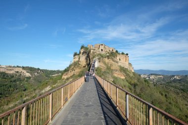 Civita di Bagnoregio İtalya 'sında turistler. Dağdaki Ortaçağ kasabasının panoramik manzarası. Tuscany, İtalya 'da popüler bir turistik durak. Köprüyü ve Tiber Nehri Vadisi 'ni çevreleyen. 