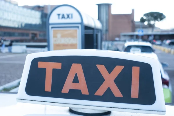 İtalya 'da bir taksi durağının yakınındaki caddede bir taksi durağı. Toplu taşıma kavramı. Kırmızılı taksi tabelası. Şehir hayatı, ulaşım, seyahat.   