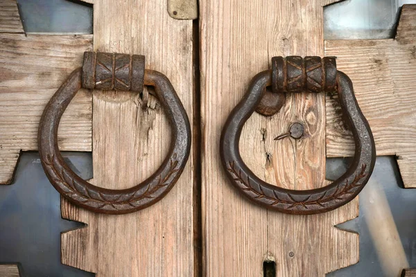 俄罗斯风格的老式木门上的一个老铁制门栓 手工锤头的锻造柄是在木门的后面用铁制的 — 图库照片