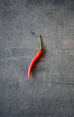 Koyu gri mutfak tezgahında kırmızı biber var. Yemek hazırlığı. Nesnelerin durgun yaşamı.    