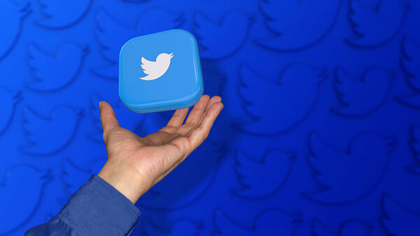 A square Twitter badge falling on a male hand on unfocused blue background.