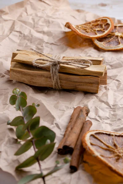 Palo Santo wood sticks on craft paper with aromatherapy accessories. Incense for meditation, aromatherapy, ceremonies and rituals, cleansing and healing. Close-up, vertical format.