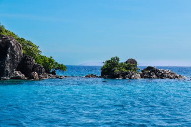 Açık gökyüzü ve adası olan güzel bir deniz