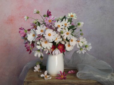 Masasında su olan vazoda kozmetik çiçekleri olan muhteşem bir buket..