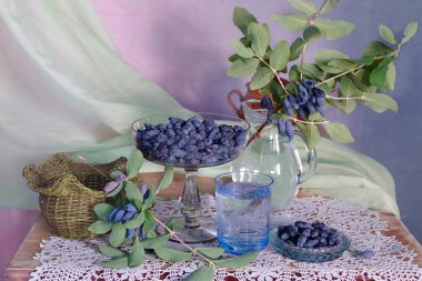 Masadaki cam vazoda olgun, lezzetli hanımeli meyveleri..