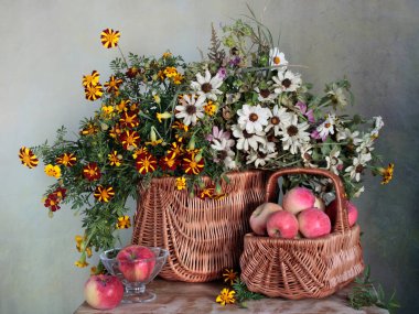 Still life with flowers in a basket and apples on the table .