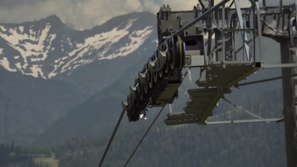 Skigebiet. Seilbahnfahrt. Rotierendes Metallrad treibt Gondel an — Stockvideo