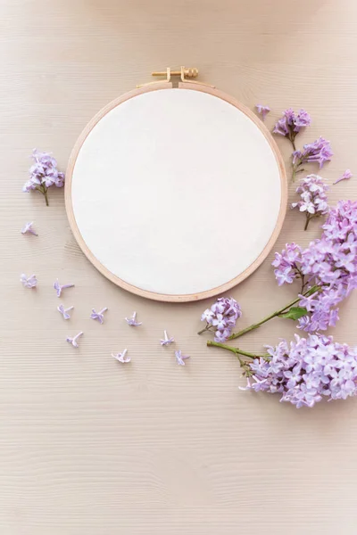 Flach liegendes Draufsicht-Foto einer Attrappe mit Stickrahmen und Lila-Blumen. — Stockfoto