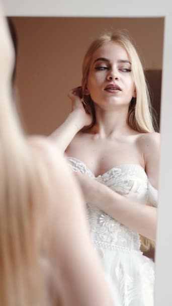 Jonge blonde vrouw in elegante witte jurk posein studio — Stockvideo