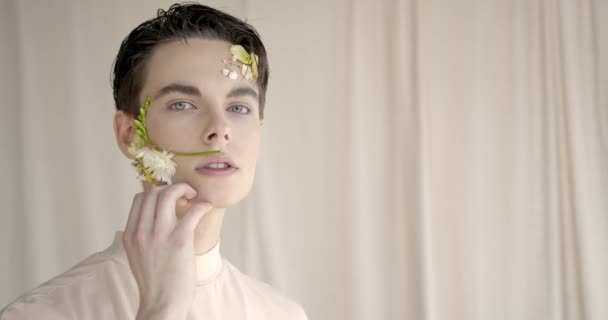 Knappe jongeman met bloemen op gezicht — Stockvideo