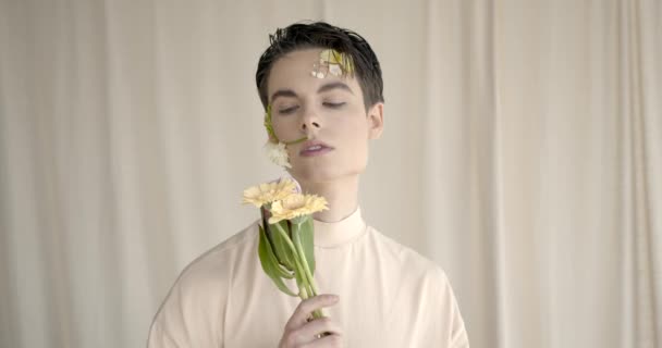 Joven guapo con flores en la cara — Vídeo de stock