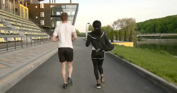 Aktivní pár jogging ve sportovním prostředí — Stock video