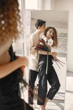 Yüzlerinde çiçekler olan bir kız ve erkeğin duygusal portresi.