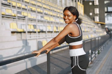 Afro-Amerikalı genç bir kadının açık hava eğitimi portresi.