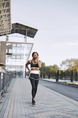 Açık havada koşan Afro-Amerikan bir kadının portresi.