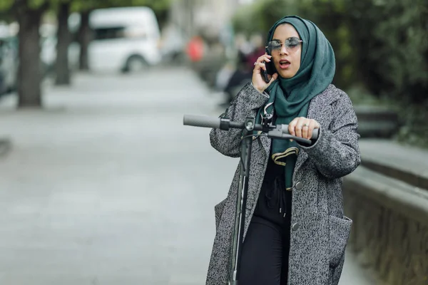路上でスクーターと緑のヒジャーブのイスラム教徒の少女の肖像画 — ストック写真