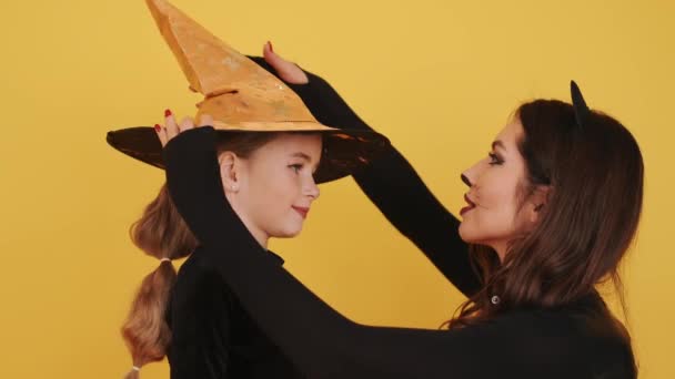 Anya és lánya viselnek halloween jelmezek a narancssárga stúdióban — Stock videók