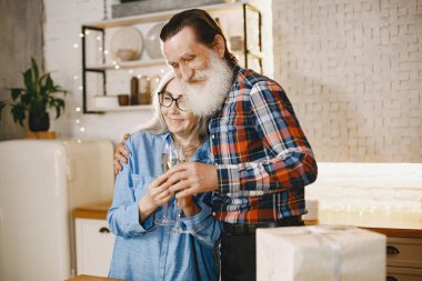 Mutfakta hediyeleri olan yaşlı bir çift.