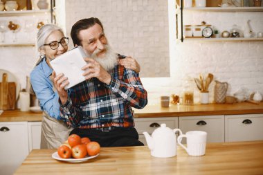 Mutfakta hediyeleri olan yaşlı bir çift.