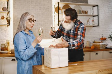 Mutfakta hediyeleri olan yaşlı bir çift.