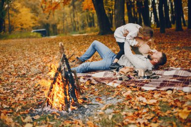 Sonbahar parkında oynayan sevimli bir aile.