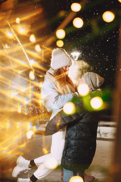 Молодая пара на открытом воздухе на ночной улице в рождественское время — стоковое фото