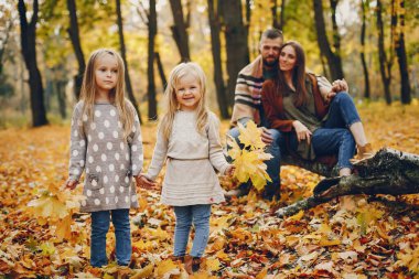 Sonbahar parkında tatlı çocuklu bir aile.