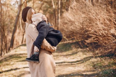 Anne ve oğlu yaz parkında oynuyorlar.