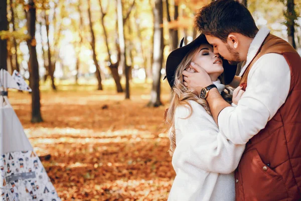 Casal elegante em um parque de outono ensolarado — Fotografia de Stock