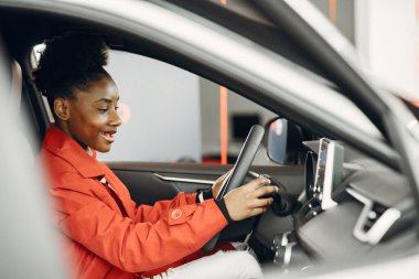 Araba galerisindeki genç Afro-Amerikan kadın.