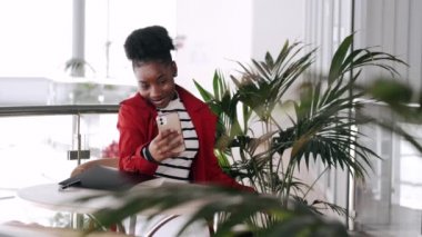 Siyah kadın iş danışmanı. Ofiste telefonla konuşuyor.