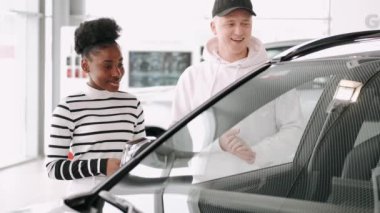 Araba satıcısından aldığı yeni arabasını kullanan siyahi bir kadın.
