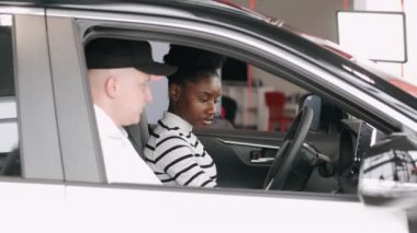 Araba satıcısından aldığı yeni arabasını kullanan siyahi bir kadın.