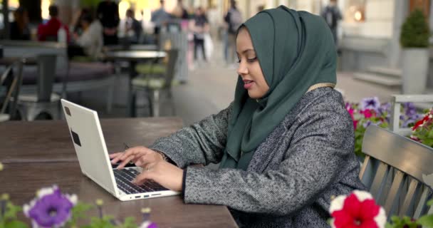 Mulher no hijab trabalhar com laptop no café — Vídeo de Stock