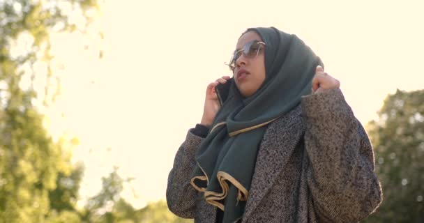 Muslimsk kvinde i slør taler via telefon udendørs – Stock-video